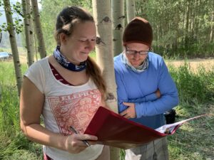 Photo: Outdoors a director and a man look at a script.